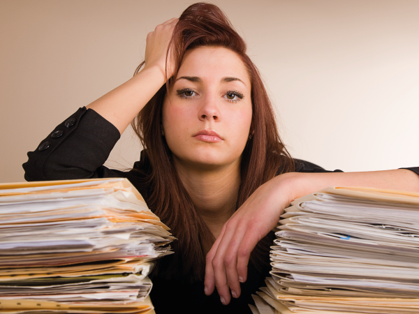 A woman with mountains of paperwork